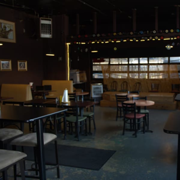 Interior of The Service Station Restaurant with tables, chairs, booths, and a stage area.