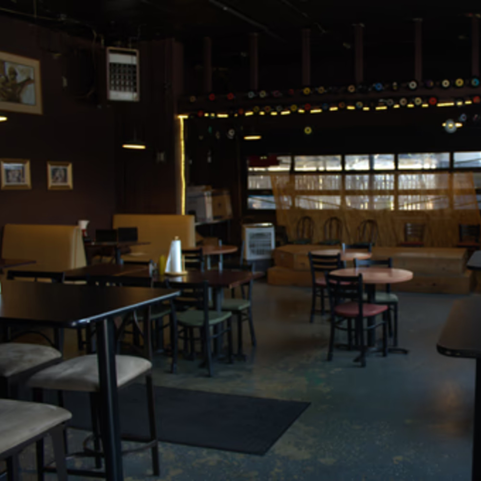 Interior of The Service Station Restaurant with tables, chairs, booths, and a stage area.